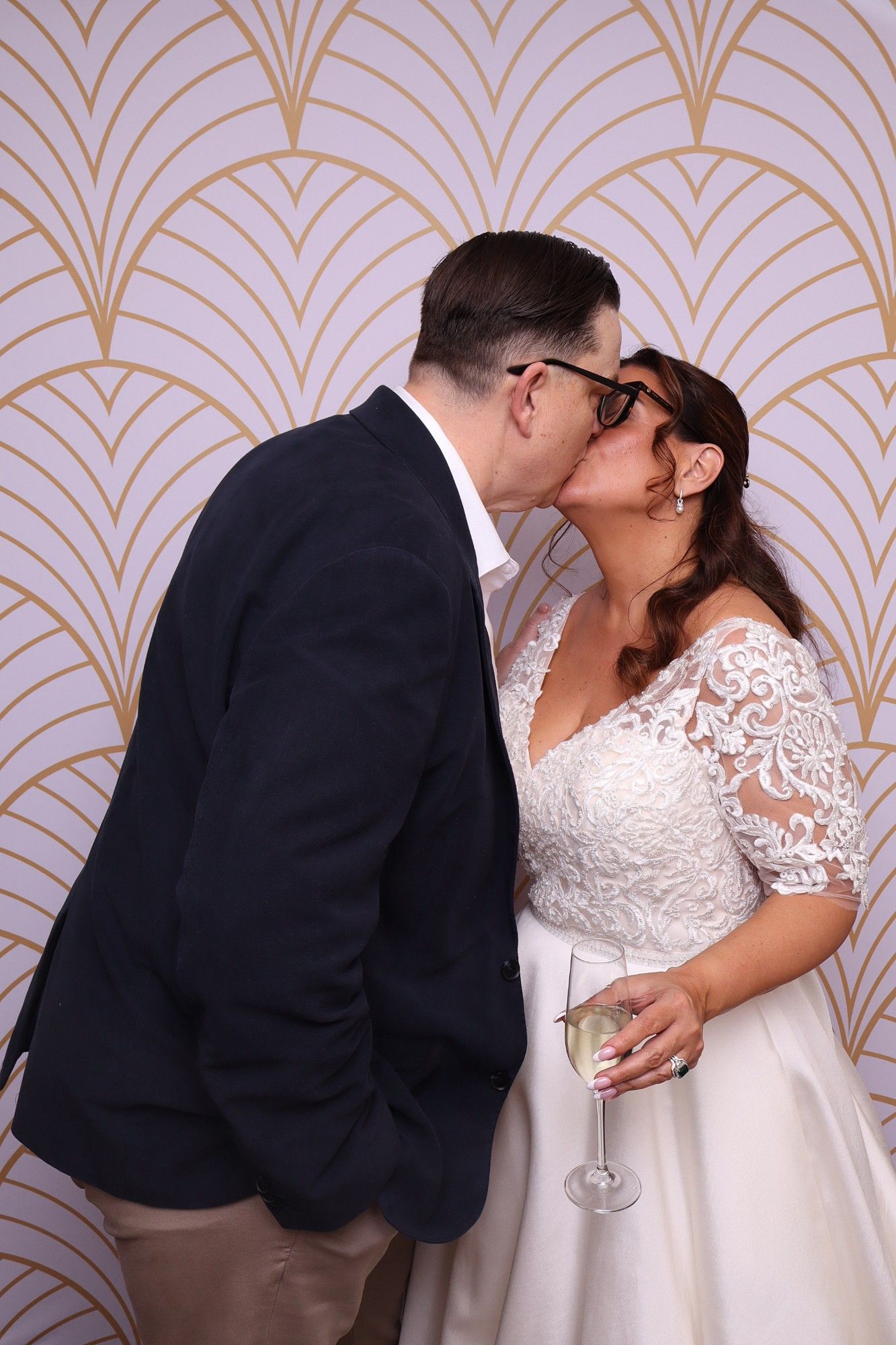 The newlyweds share a kiss in front of an art deco backdrop at the Ginninderry Homestead photo booth