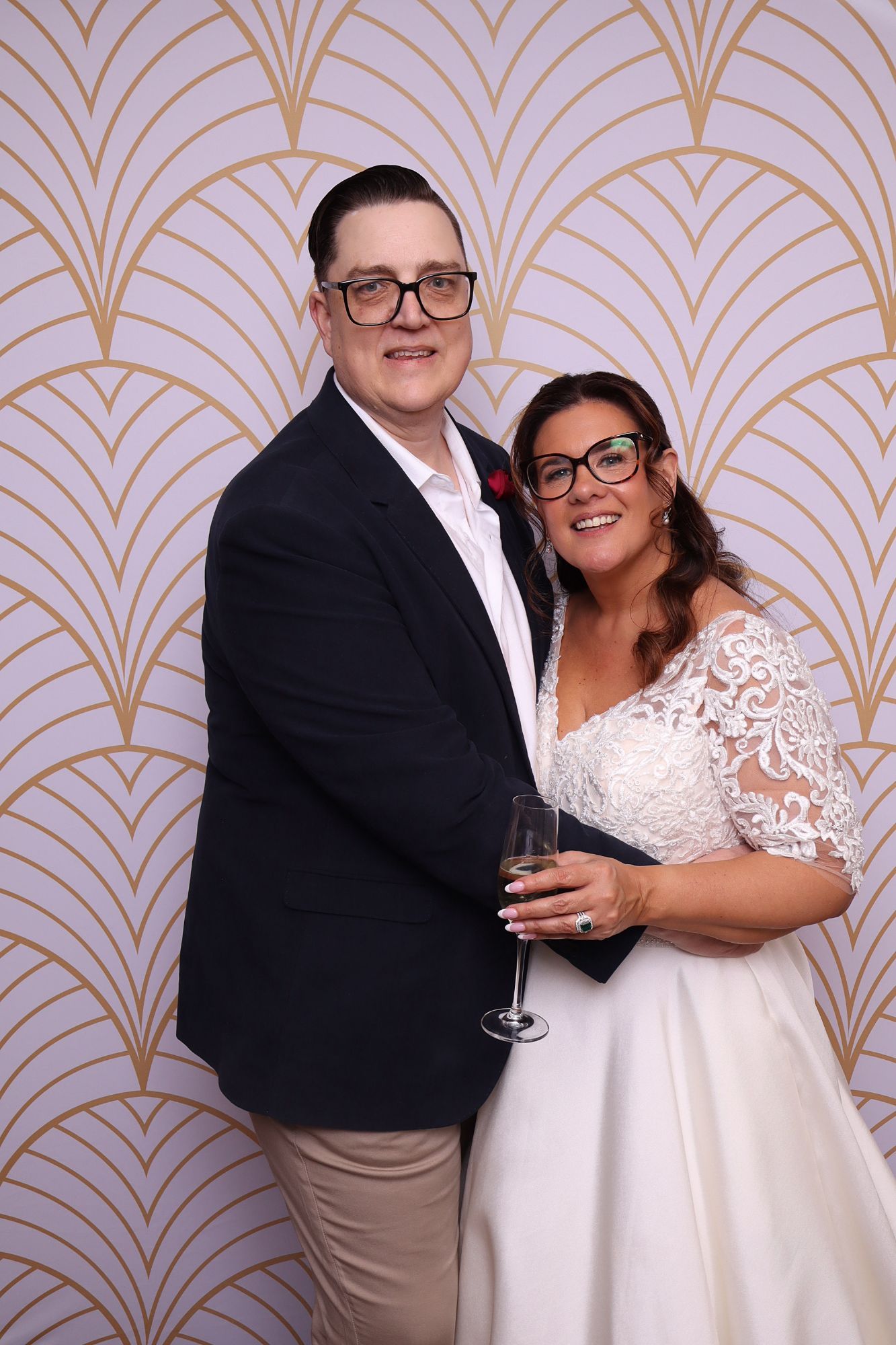 The newly married couple pose with champagne against an art deco backdrop at their Ginninderry Homestead wedding