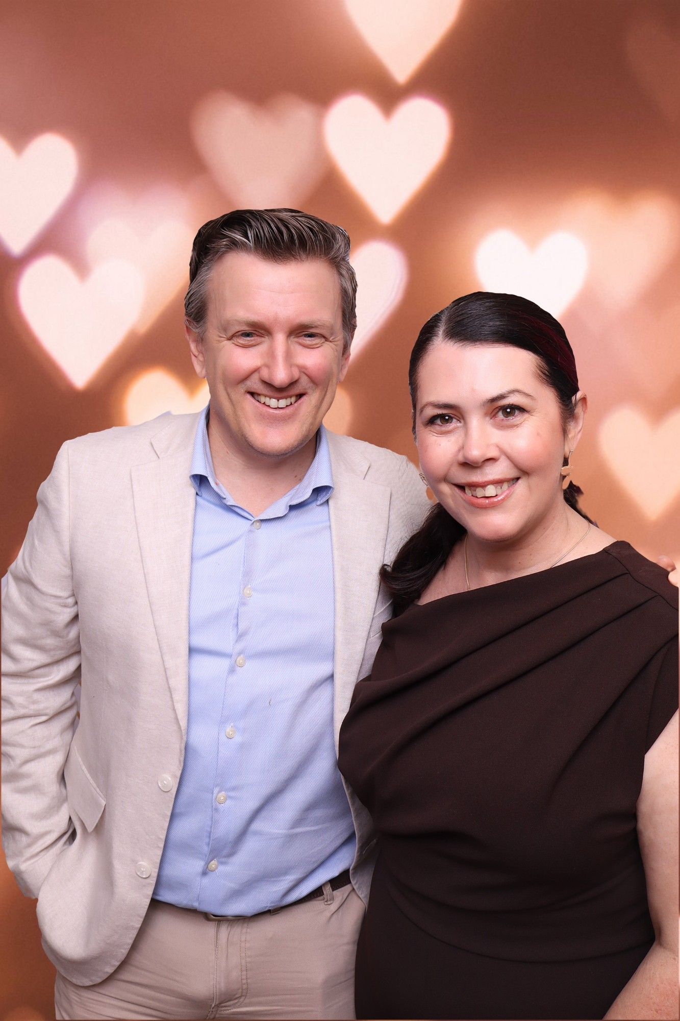 Wedding guests posing together against a heart bokeh backdrop at the Ginninderry Homestead photo booth