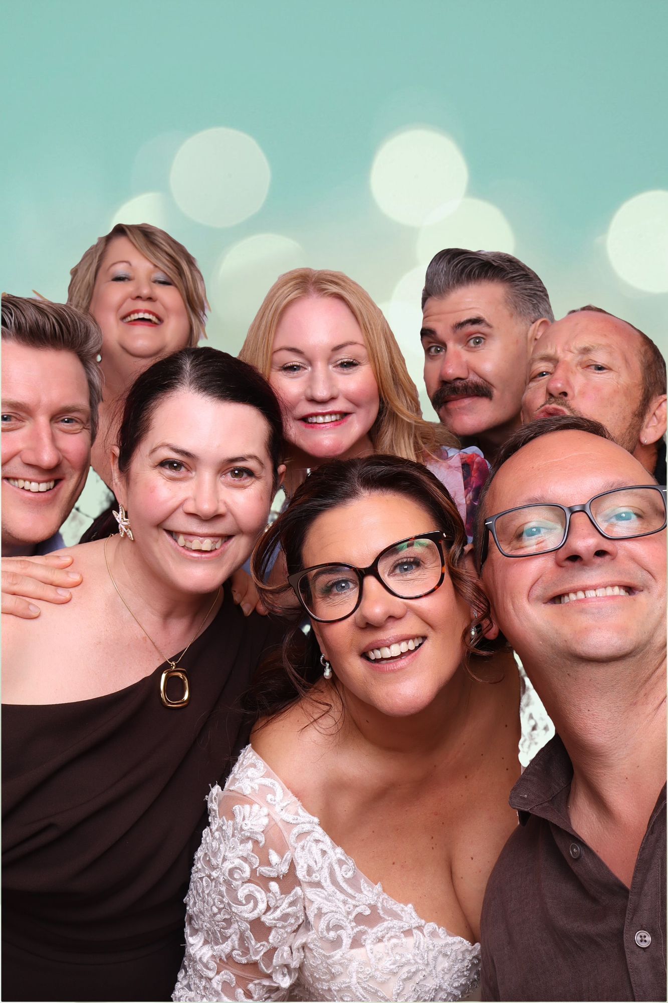 The bride squeezes into the photo booth with a group of laughing guests at Ginninderry Homestead